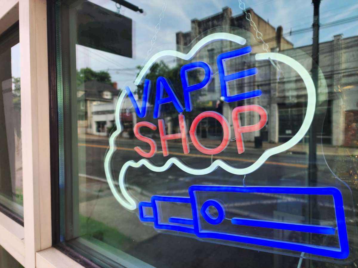 Neon vape shop sign in a storefront window